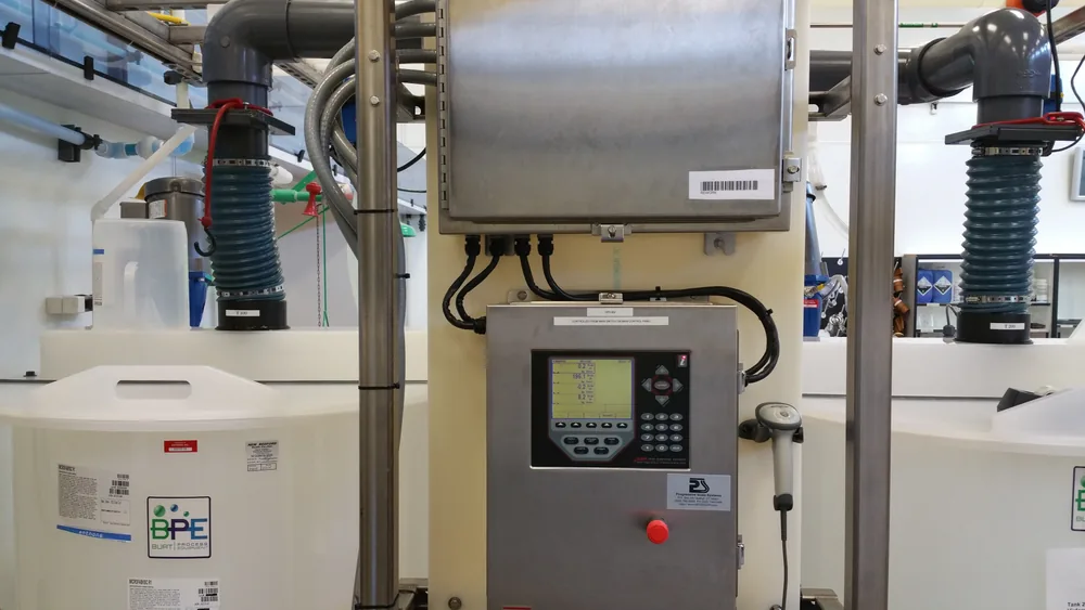 A filling and batching control panel with a Rice Lake indicator and emergency stop, plumbed to load-cell mounted supply tanks.