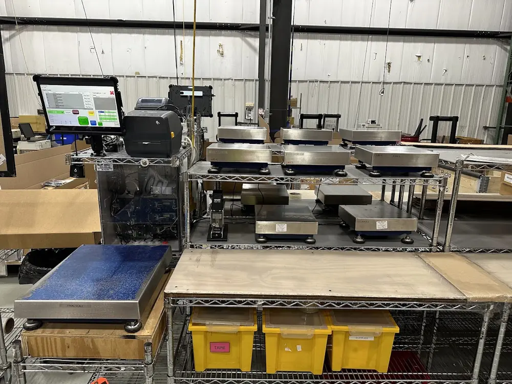 A counting station: a touchscreen terminal running the counting application beside a label printer and a rack of six labelled networked bench scales, with a final-check platform in front.